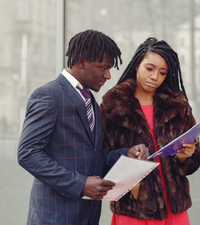 Black couple. Woman in a red dress. Man in a suit. Businesspeople.